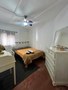 a bedroom with a bed and a dresser and a ceiling fan at Casa La Ferrata in Jimera de Líbar
