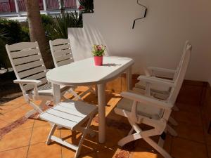 a white table and chairs with a potted plant on it at Playa del Cura - Beachside Retreat in Playa del Cura