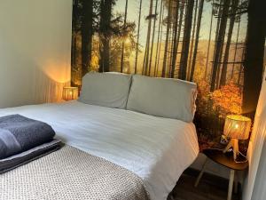 a bedroom with a bed with a painting of a forest at The Truck with private hot tub -Garvagh retreats in Ballynameen +26 photos