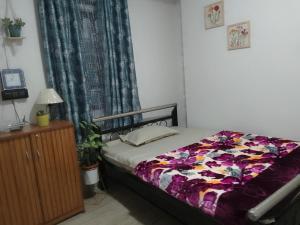 a bedroom with a bed with a colorful comforter at Mist N Mountain in Kurseong +32 photos