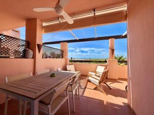 a dining room with a table and chairs on a patio at Condado de Alhama la isla 7SV2D in El Romero
