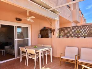 a patio with a wooden table and chairs at Condado de Alhama la isla 7SV2D in El Romero