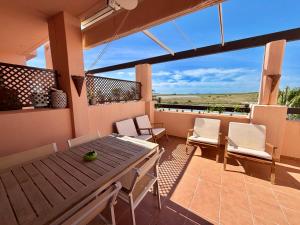 a patio with a table and chairs on a balcony at Condado de Alhama la isla 7SV2D in El Romero +6 photos