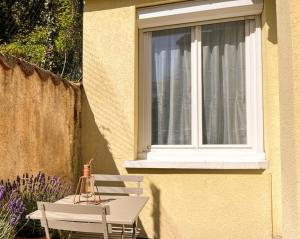 a white table and chair next to a window at La maisonnette 70' in Groseillier