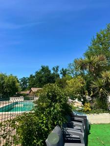 a row of benches sitting next to a swimming pool at CHALET SUR PILOTIS - 4 personnes - CLIMATISÉ- PISCINE- PROCHE PLAGE in Arès
