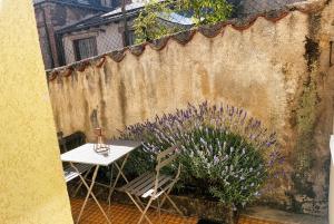 a table and chairs next to a fence with purple flowers at La maisonnette 70' in Groseillier +1 photo