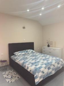 a bedroom with a bed with a blue and white comforter at Ostojic lux apartman in Kotor +20 photos