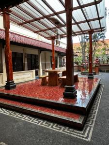 Ein Pavillon mit einem Tisch und Bänken auf einem roten Teppich in der Unterkunft Hotel Pesaban in Tjakranegara + 2 Fotos