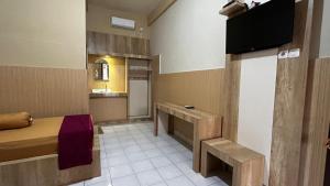 ein Zimmer mit einem Bett und einem Fernseher in der Unterkunft Hotel Pesaban in Tjakranegara