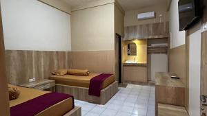ein Hotelzimmer mit zwei Betten und einem Badezimmer in der Unterkunft Hotel Pesaban in Tjakranegara