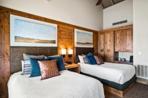 two beds in a room with wooden walls at Sunriver Resort in Sunriver