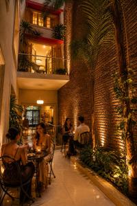 a group of people sitting at tables in a restaurant at Duque Hotel Boutique & Spa in Buenos Aires
