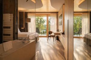 a bedroom with a bed and a bathroom with a sink at Buff Medical Resort Konstanz in Konstanz