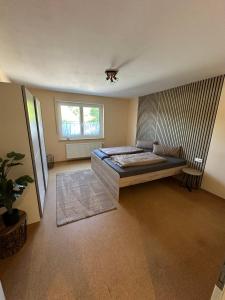 a large bedroom with a bed and a window at Haselbach Living in Ehekirchen