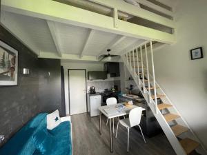 a room with a staircase and a table and chairs at La Louvatière 28 in Mijoux