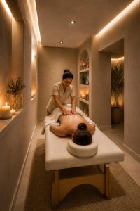 a woman sitting on a bed in a massage room at Duque Hotel Boutique & Spa in Buenos Aires
