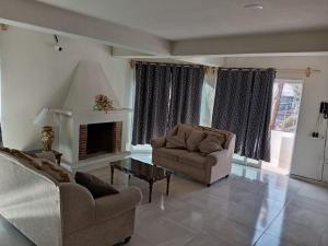 a living room with two chairs and a fireplace at Mi Casa Morelia in Morelia