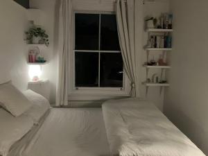 a bedroom with a white bed and a window at Beautiful City Centre Apartment with Cathedral View in St. Albans