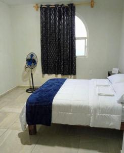 a bedroom with a bed and a window with a fan at Mi Casa Morelia in Morelia +9 photos