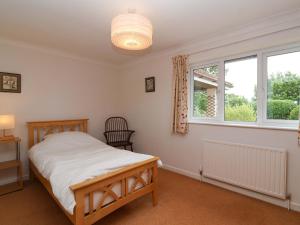 a bedroom with a bed and a window at Meadowcroft in Watchet