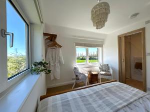 a bedroom with a bed and a window and a chandelier at Sunset View - Luxury accommodation in the Cotswolds in Tewkesbury +111 photos