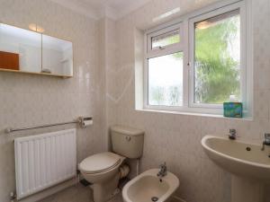 a bathroom with a toilet and a sink and a window at Meadowcroft in Watchet +49 photos