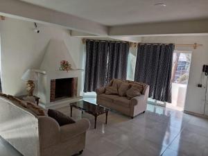 a living room with two couches and a fireplace at Mi Casa Morelia in Morelia