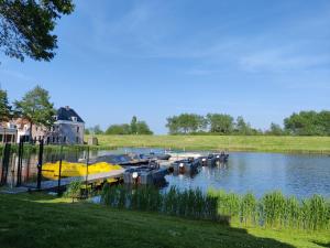 a group of boats are docked on a river at Irina - Peaceful Holiday Home near Lauwersmeer National Park in Anjum