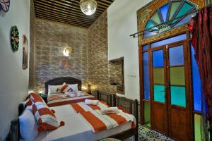 a bedroom with two beds and a window at Riad Zayna Fes in Fez