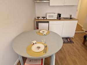a small kitchen with a white table with plates on it at 4 Seasons studio in Marinha das Ondas