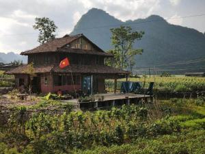 a house with a chinese flag in front of it at Nùng Indigo in Cao Bằng