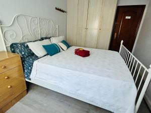 a white bed with a red bag on top of it at Espaciosa y Luminosa in San Sebastián +1 photo