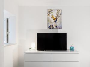 a flat screen tv sitting on top of a white cabinet at Luxury Appartament Piazza Roma in Ancona