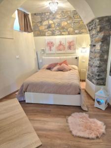 a bedroom with a bed and a stone wall at Serendipity in Arnasco +38 photos