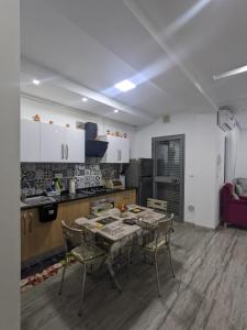 a kitchen with a table and chairs in a room at MahdiaRafeha in Mahdia