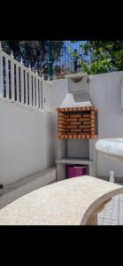 a white fence with a table and a grill at Dolls House in Lagos