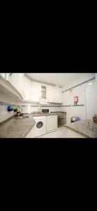 a kitchen with white cabinets and a washing machine at Dolls House in Lagos