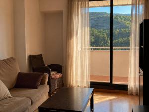 a living room with a couch and a large window at Refugio PIRENAICO in Sabiñánigo