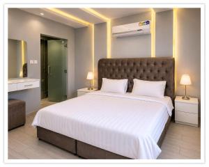 a bedroom with a large bed with white sheets at شاليهات الفيه in Khamis Mushayt