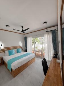 a bedroom with a large bed with blue pillows at Boli Dhigurah in Dhigurah