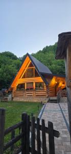 a large wooden cabin with a fence in front of it at Brvnara Floridita u prirodi - blizu Manastira Tavna in Ugljevik