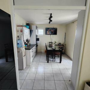 a kitchen and dining room with a table and refrigerator at Pine Tree House in Bar