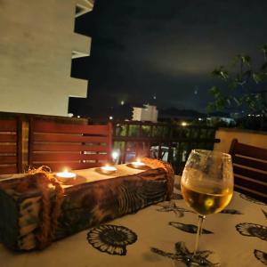 a glass of wine sitting on a table with candles at Pine Tree House in Bar