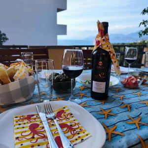 a table with a bottle of wine and a plate of food at Pine Tree House in Bar