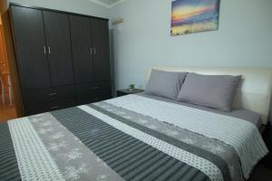 a bedroom with a large bed and a cabinet at KALLIOPIs HOUSE in Paralia Katerinis