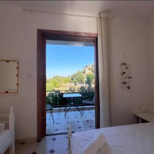 a bedroom with a window with a view of a patio at Petros Studios in Nea Epidavros