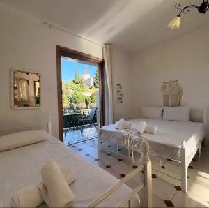 a bedroom with two beds and a balcony at Petros Studios in Nea Epidavros