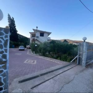 a house with a car parked in a parking lot at Petros Studios in Nea Epidavros