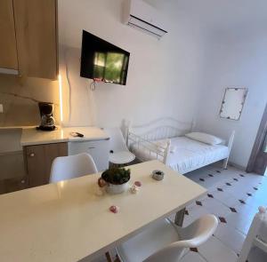 a small room with a table and chairs and a bed at Petros Studios in Nea Epidavros