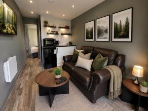 a living room with a leather couch and a table at The Truck with private hot tub -Garvagh retreats in Ballynameen